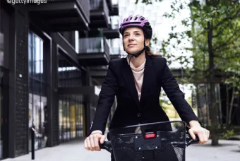 Femme à vélo avec un casque rose